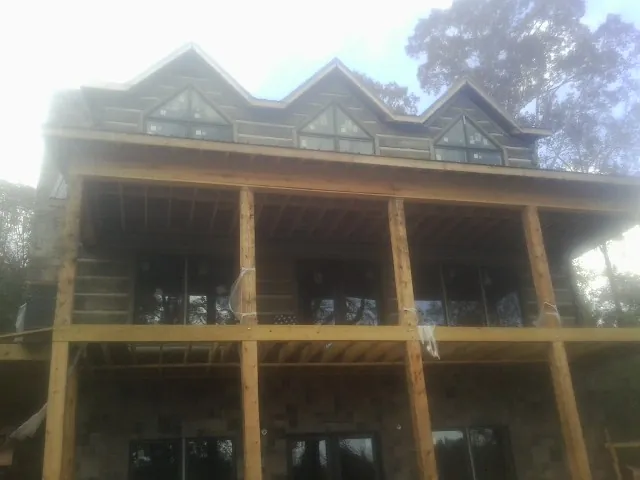 Dormers and porch framing on a large log home under construction — Roof Coating work by our crew in Hatfield